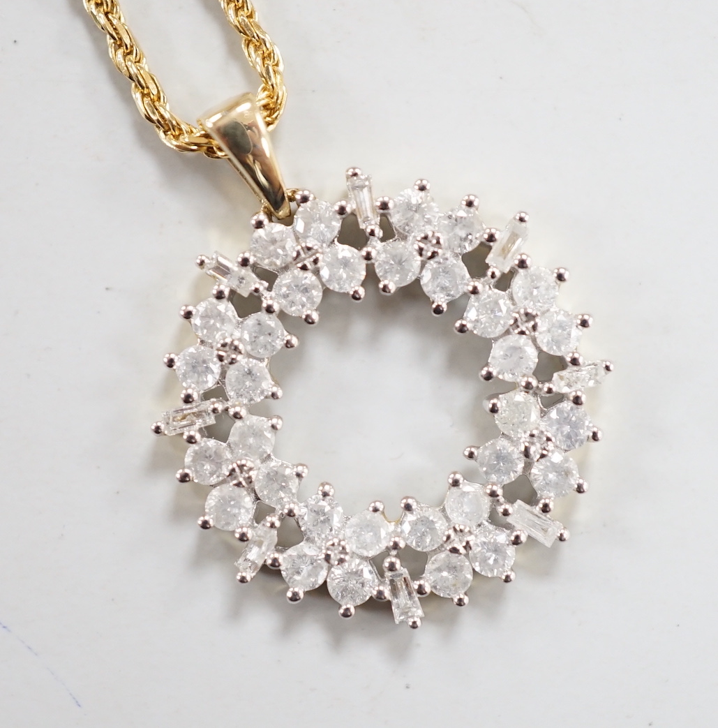 A modern 9ct gold, baguette and round cut diamond cluster set openwork pendant, diameter 17mm, gross 1.9 grams, on a modern 750 yellow metal fine rope twist chain, 48cm, 5.1 grams.